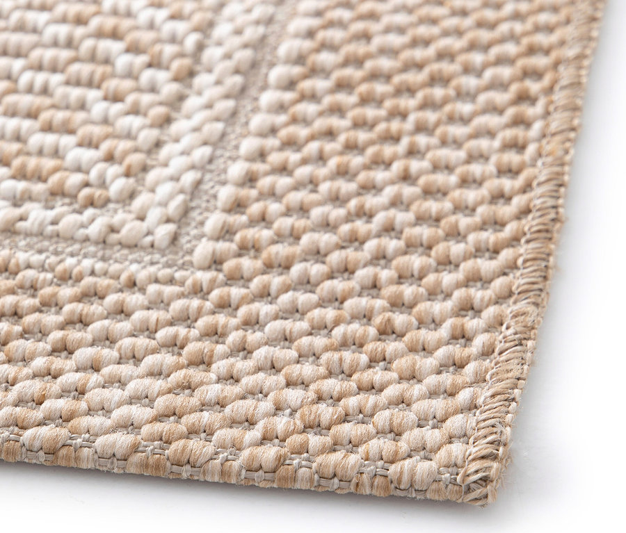 Detailansicht eines beigen »Twine« Teppichs mit Fischgrätenmuster.