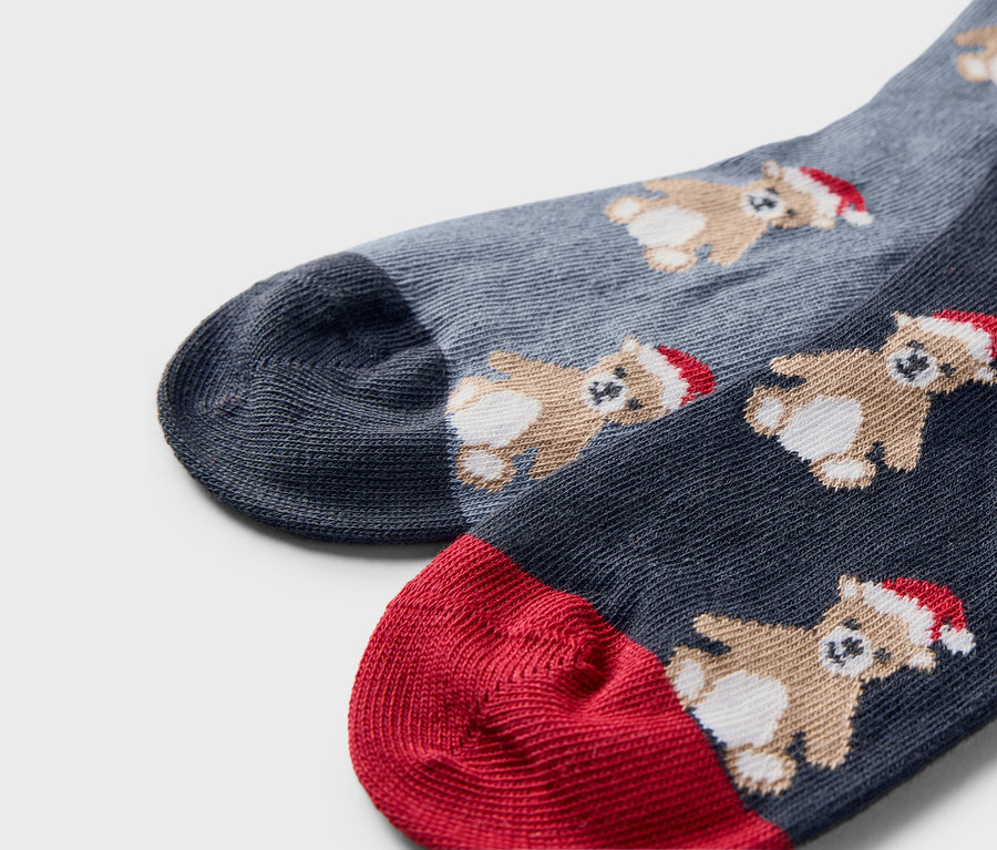 Detailaufnahme von zwei Paar Weihnachtssocken mit Bären mit Mützen.