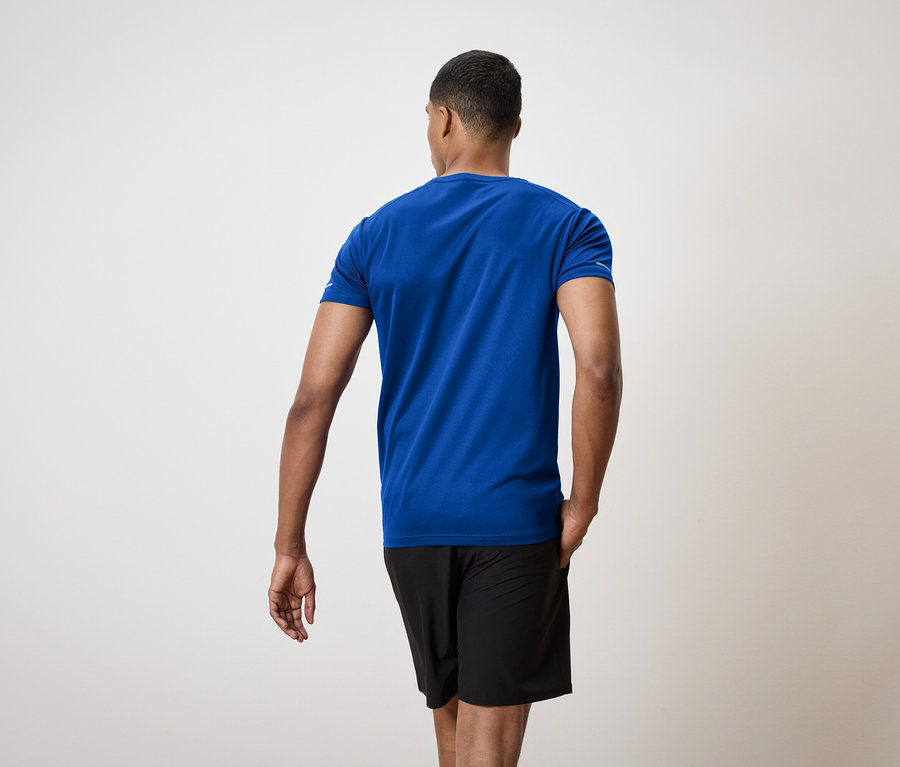 Mann von hinten trägt ein blaues T-Shirt und schwarze Shorts.