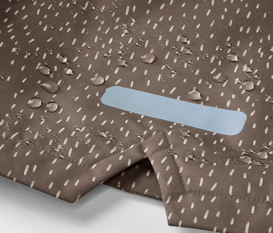Detailaufnahme einer Kinder-Thermo-Regenjacke mit Wassertropfen und Reflektor.