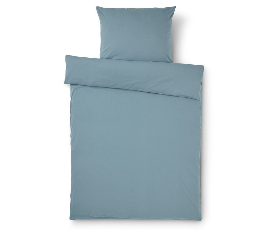 Hellblaue Bettwäsche und Kissenbezug auf weißem Hintergrund.