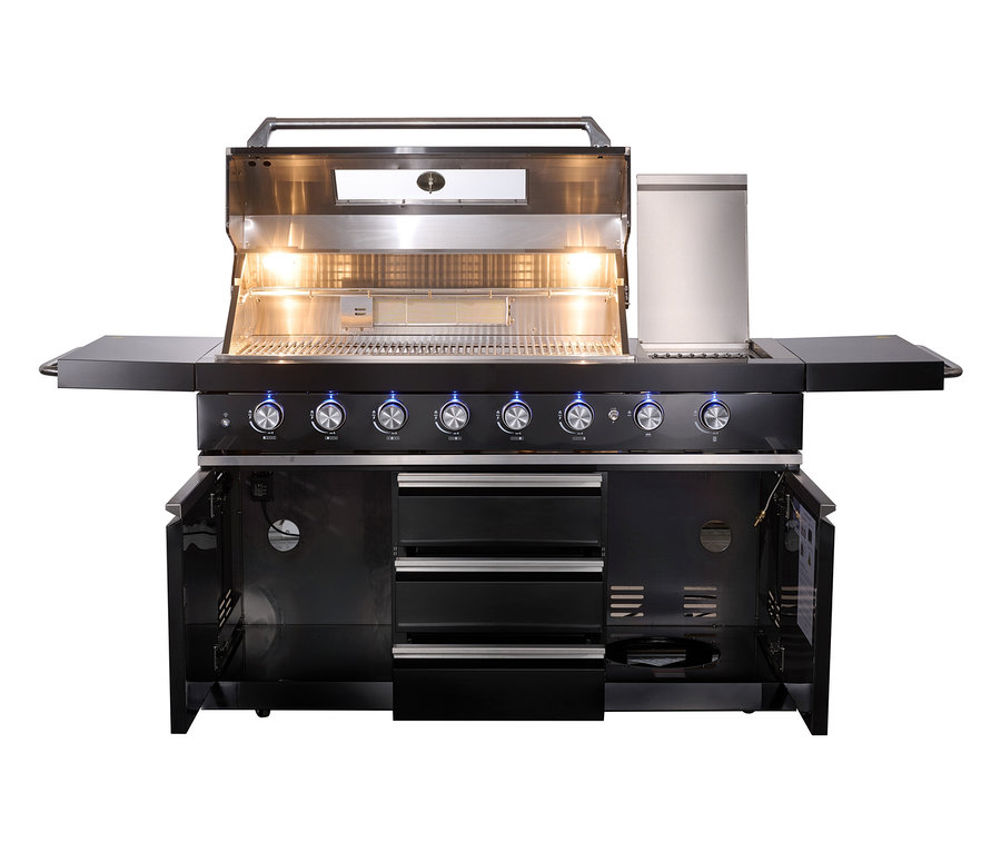 Die Buschbeck Outdoorküche »Chester« mit geöffnetem Grilldeckel und Wetterschutzhülle steht auf einer Terrasse.