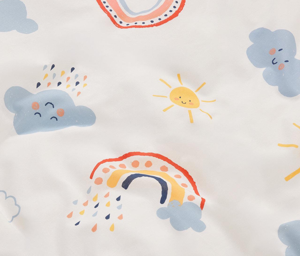 Nahaufnahme eines Stoffes mit Cartoon-Regenbögen, Wolken und Sonnen auf einem weißen Hintergrund.