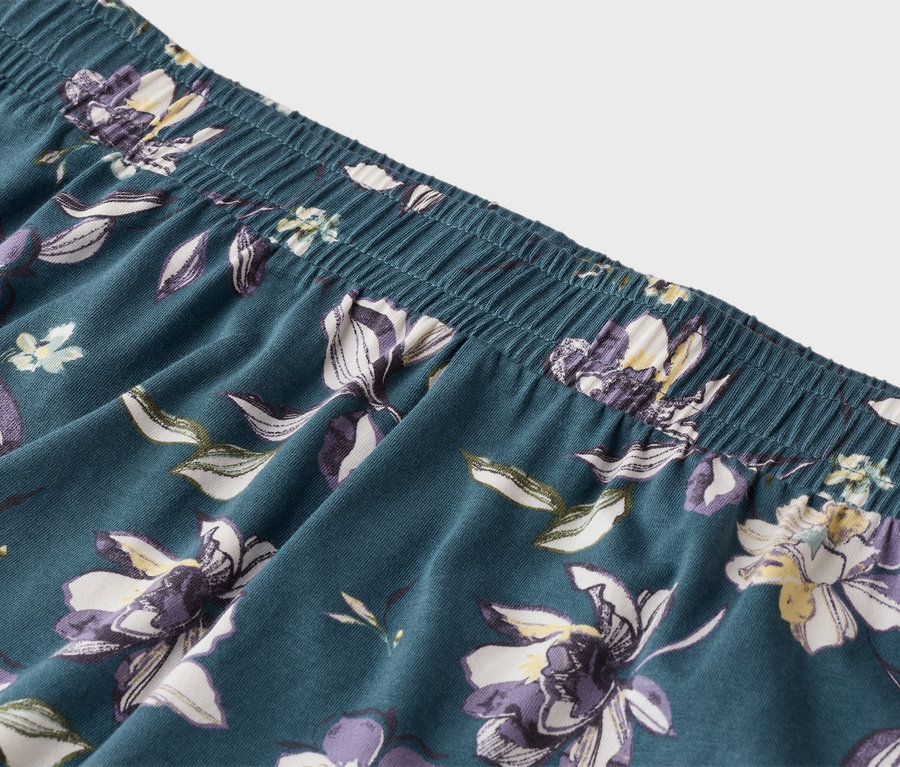 Nahaufnahme einer blauen Pyjamahose mit elastischem Bund und Blumenmuster.