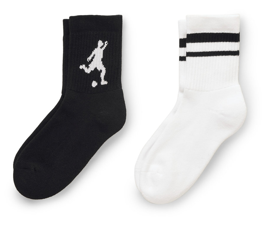 Nahaufnahme von zwei Socken, eine schwarze Socke mit einem weißen Fußballspieler darauf und eine weiße Socke mit drei schwarzen Streifen oben.
