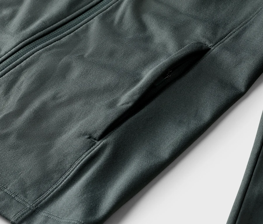Nahaufnahme einer grauen Jacke mit Reißverschluss und einer Reißverschlusstasche.
