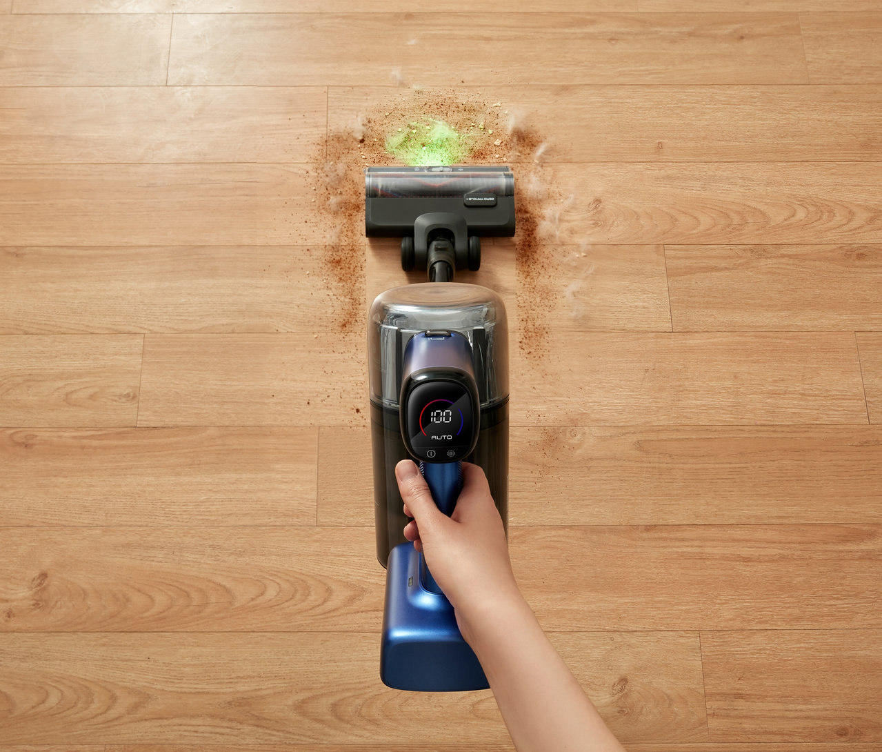 Hand saugt mit Tineco Akku-Staubsauger »Pure One S50 Pro« Krümel vom Holzboden.