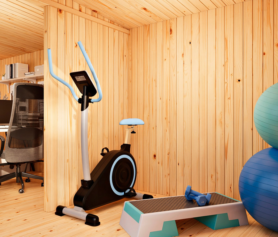 Ein Raum mit hellen Holzwänden und -boden, aufgeteilt in ein Home-Office links und einen Fitnessbereich rechts. Der Fitnessbereich enthält ein schwarz-blaues Heimtrainer-Fahrrad, ein weiß-blaues Aerobic-Step mit blauen Hanteln und zwei gestapelte Gymnastikbälle (türkis und blau).