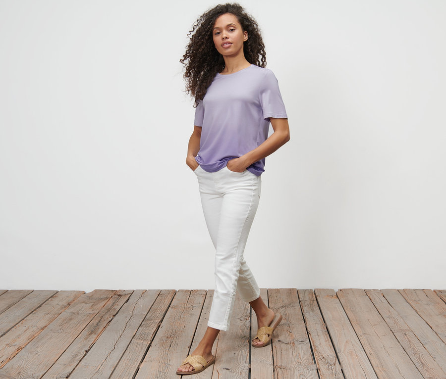 Frau geht, trägt ein Dip-Dye-T-Shirt, weiße Hose und Sandalen.