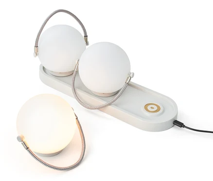 Akku-Tischleuchten-Set: Zwei Lampen auf einer Ladestation und eine einzelne Lampe.