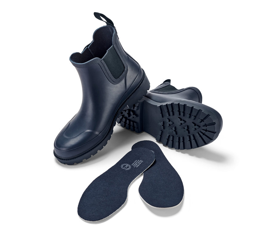Marineblaue Regenstiefeletten und Einlegesohlen auf weißem Hintergrund.