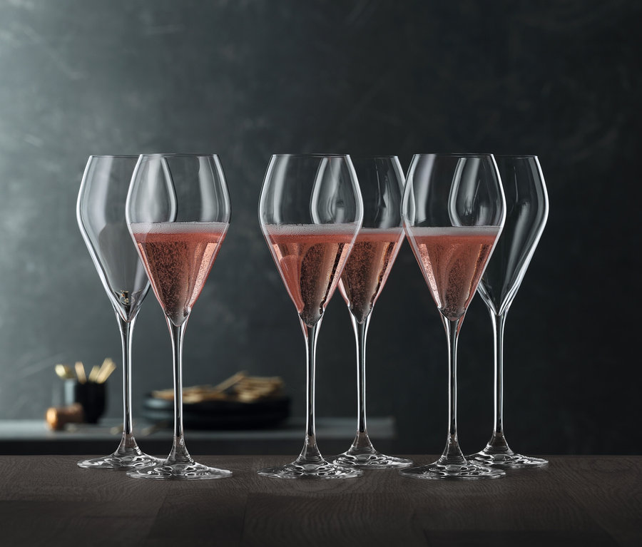 Sechs Spiegelau Sparkling Party Gläser, 230 ml, stehen auf einem Tisch, vier davon sind mit einem rosafarbenen Getränk gefüllt.