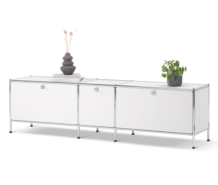 Weißes Lowboard »CN3« mit 3 Klappen. Auf dem Schrank stehen eine Vase, ein Buch und eine Topfpflanze.