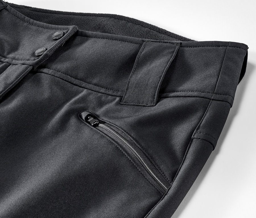 Detailaufnahme einer schwarzen Jet-Skihose mit Knopfverschluss und Reißverschlusstasche.