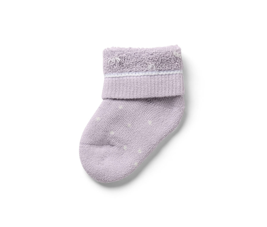 Nahaufnahme einer einzelnen lila Baby-Socke mit weißen Punkten. 7 Paar Baby-Socken, Schwan.