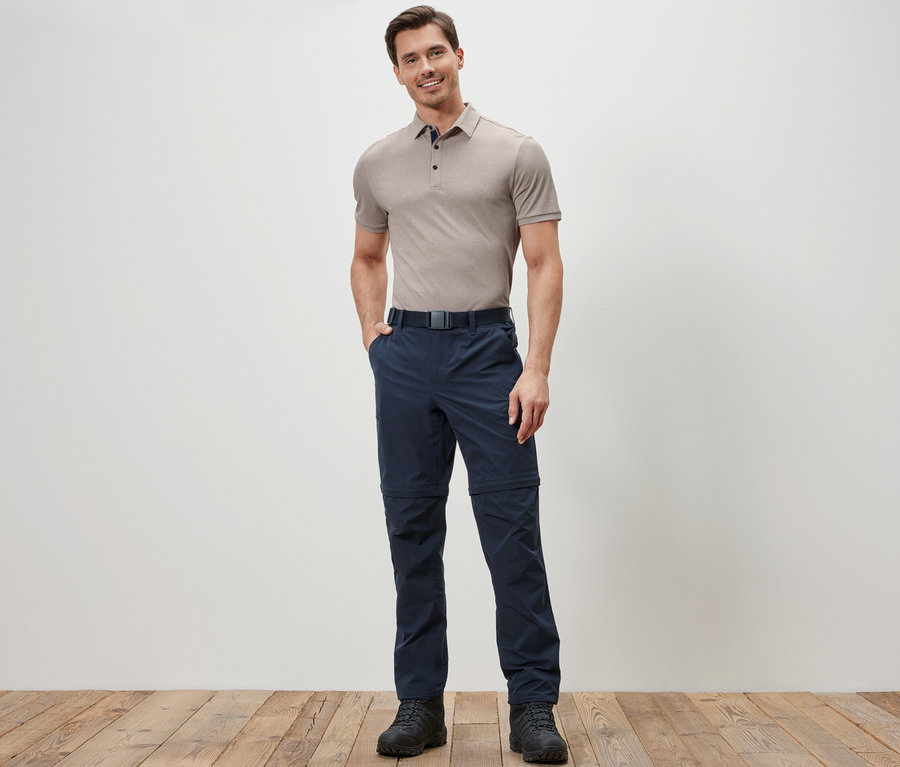 Mann posiert in blauen 2-in-1-Funktionshosen.