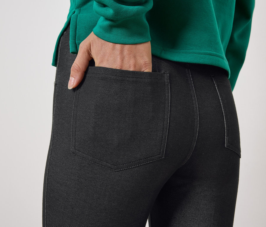 Detailaufnahme von schwarzen Damen-Jeggings mit Hand in der Tasche.