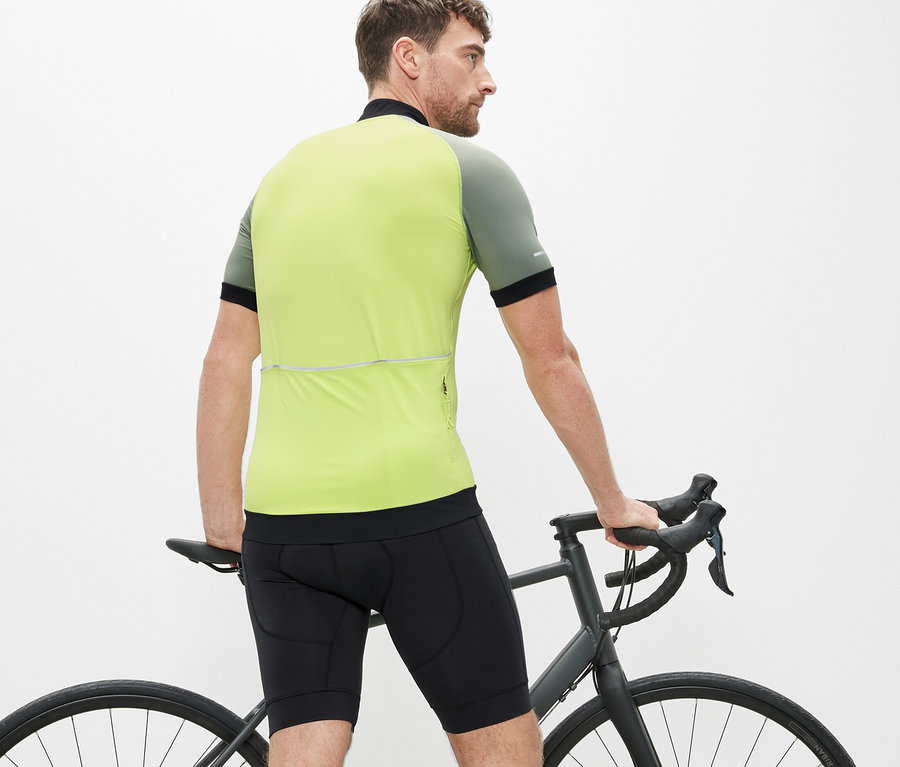 Mann steht neben einem Fahrrad und trägt eine Fahrradhose.