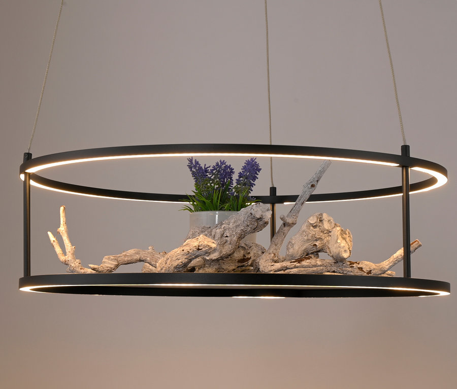 Schwarze ringförmige LED-Hängeleuchte mit Blumen und Treibholz.