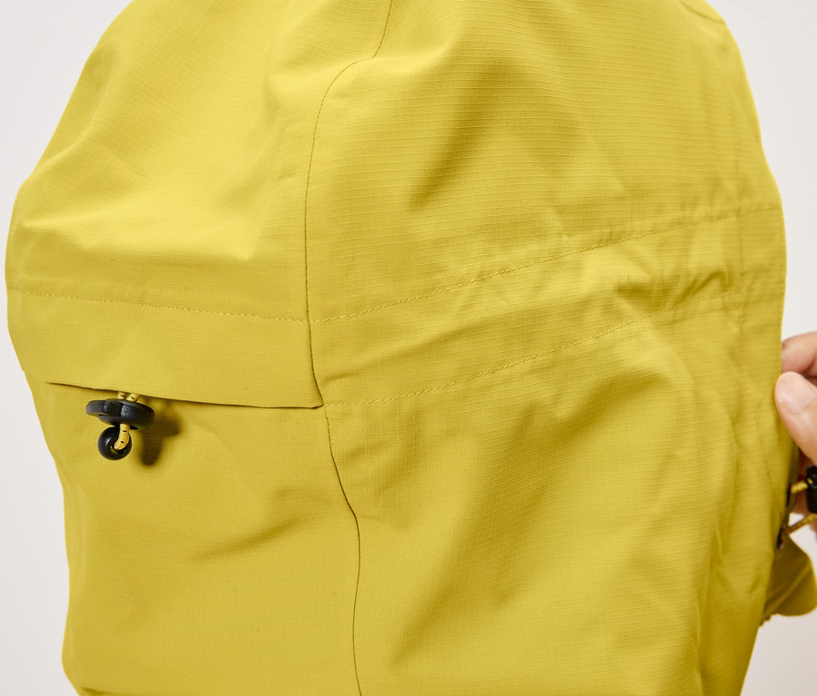 Detailansicht der Kapuze einer gelben Jacke mit Kordelzug.