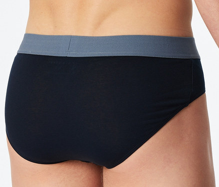 Rückenansicht eines Mannes, der schwarze SCHIESSER Slips mit grauem Bund trägt.