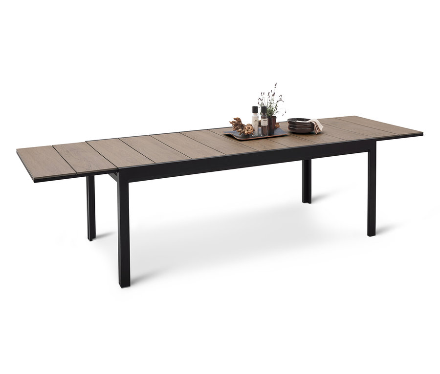 Ein langer Esstisch mit schwarzem Rahmen und hölzerner Tischplatte, auf dem ein Tablett mit Dekorationen steht.