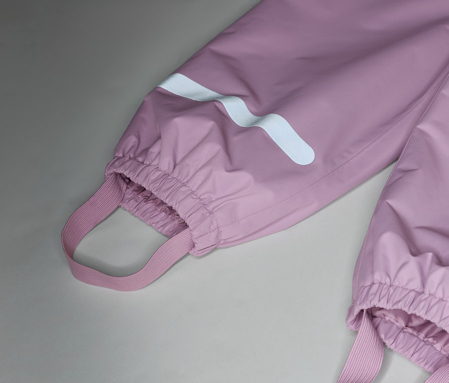 Nahaufnahme von rosafarbenen Regenhosen mit elastischen Trägern und reflektierenden Streifen an den Beinen.