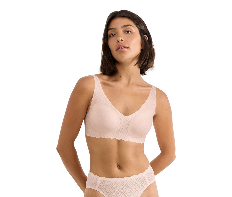 Frau trägt einen hellrosa BH und Slip mit Muster.