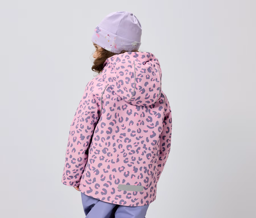 Rückansicht eines Kindes mit lila Mütze und rosa Jacke mit Leopardenmuster vor einem grauen Hintergrund.