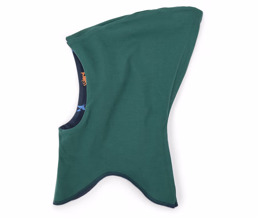 Ein grüner Sturmhut mit marineblauem Saum und einem Innenfutter mit einem Muster aus Tieren liegt auf einem weißen Hintergrund.