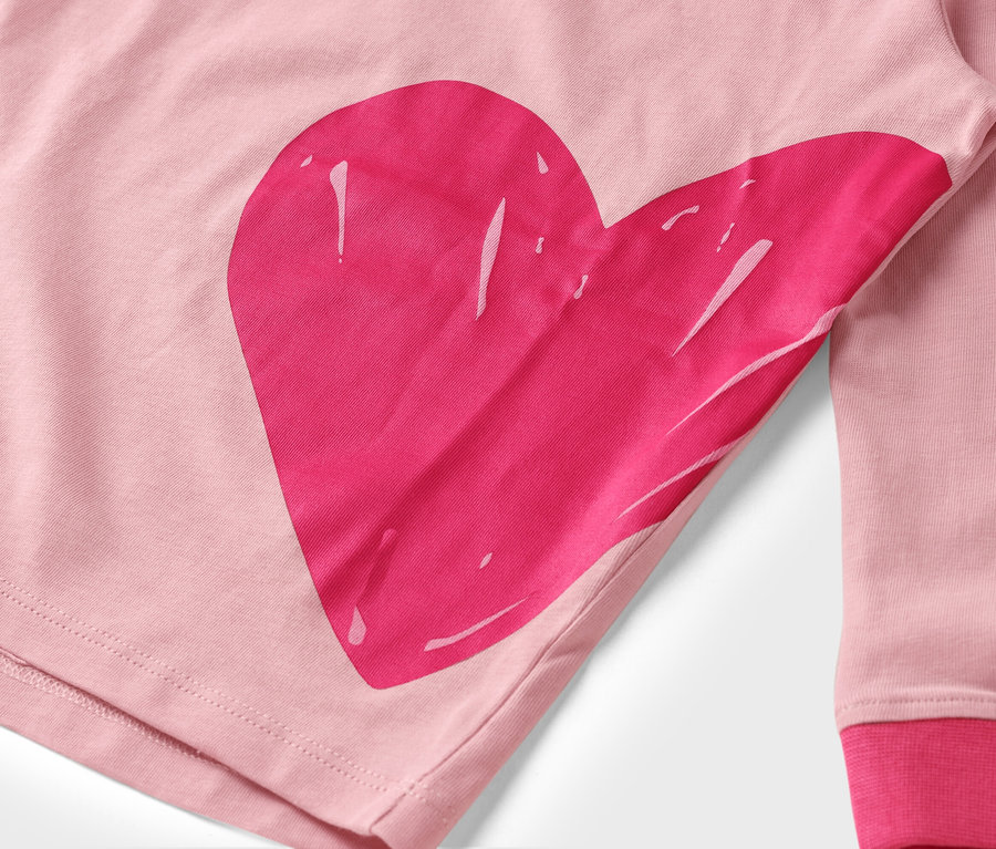 Nahaufnahme eines rosa Stoffes mit einem großen, pinken Herzaufdruck.