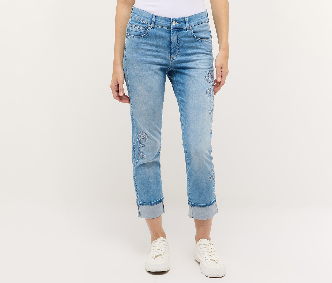 Person trägt Angels Denim »Cira Boho« Jeans und weiße Turnschuhe vor einem weißen Hintergrund.