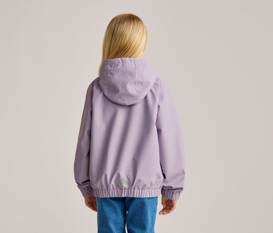 Rückansicht eines Kindes mit blonden Haaren, das eine lila Jacke mit Kapuze und blaue Jeans trägt.