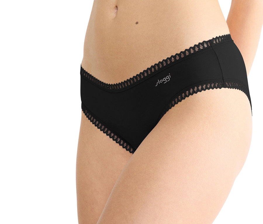 Nahaufnahme einer Frau, die schwarze Sloggi-Unterwäsche mit Spitzenbesatz trägt.