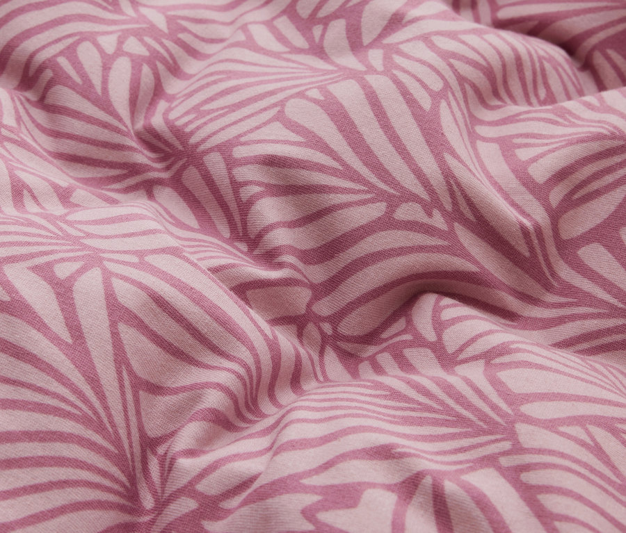 Rosa Stoff mit einem dunkleren rosa Blattmuster, in weichen Falten drapiert.