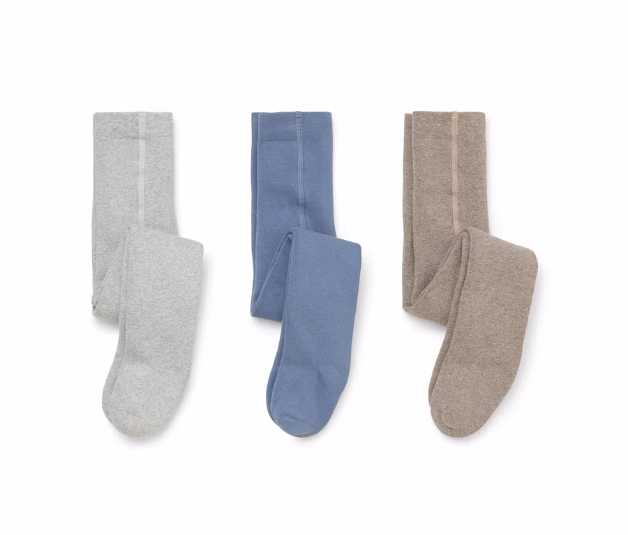 Drei Paar gefaltete Strumpfhosen liegen auf einem weißen Hintergrund: hellgrau, blau und beige.