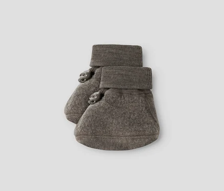 Ein Paar graubraune Babyschühchen mit gerippten Bündchen und zwei kleinen Zierknöpfen an der Seite jedes Schühchens.