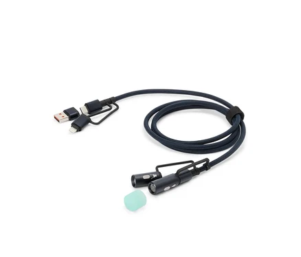 Ein blaues Ladekabel mit USB-, USB-C- und Lightning-Anschlüssen sowie zwei kleinen LED-Leuchten und einem Silikonaufsatz liegt auf einem weißen Hintergrund.