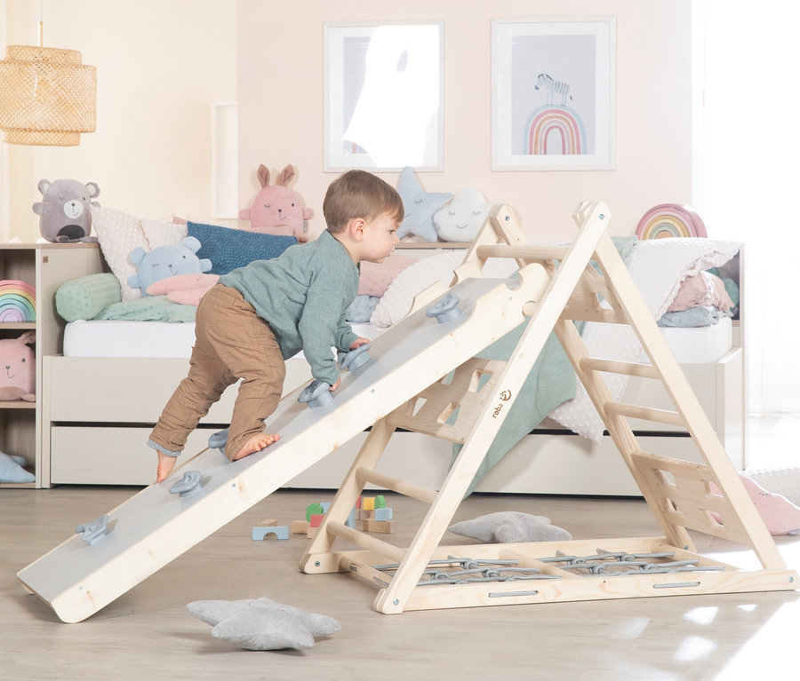 Junge klettert auf roba Kletterdreieck im Kinderzimmer.