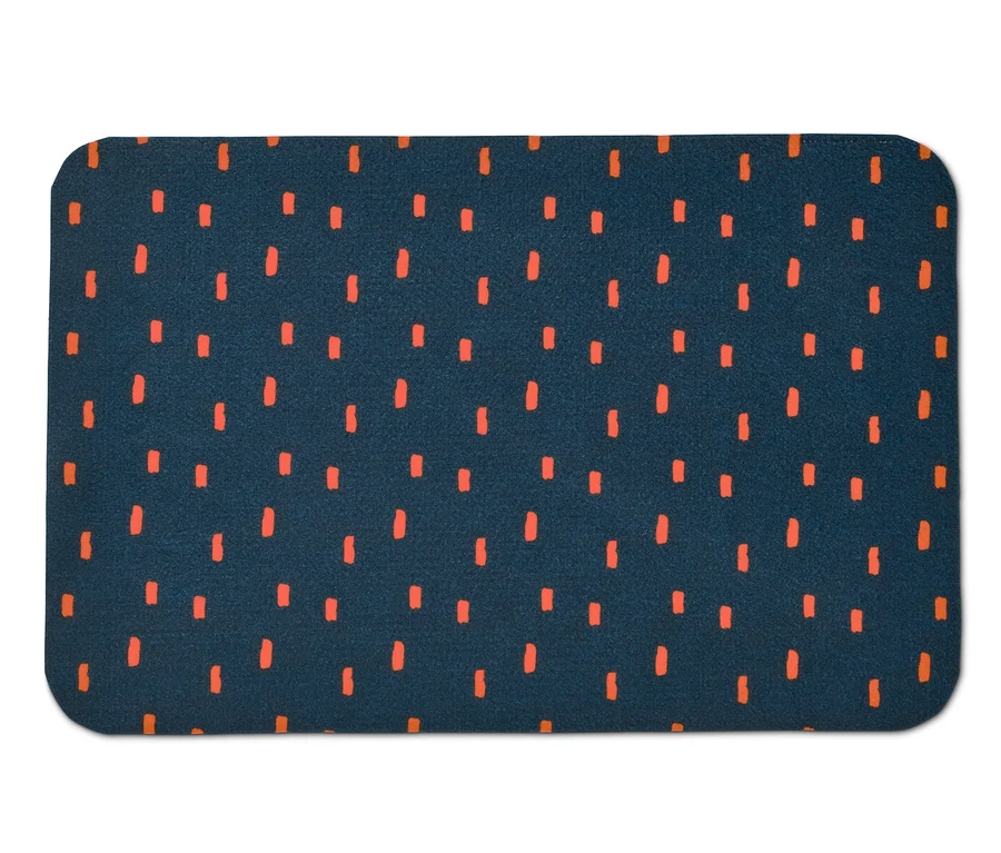 Eine Napfunterlage aus Vlies mit einem dunkelblauen Hintergrund und orangenfarbenen Strichmustern.