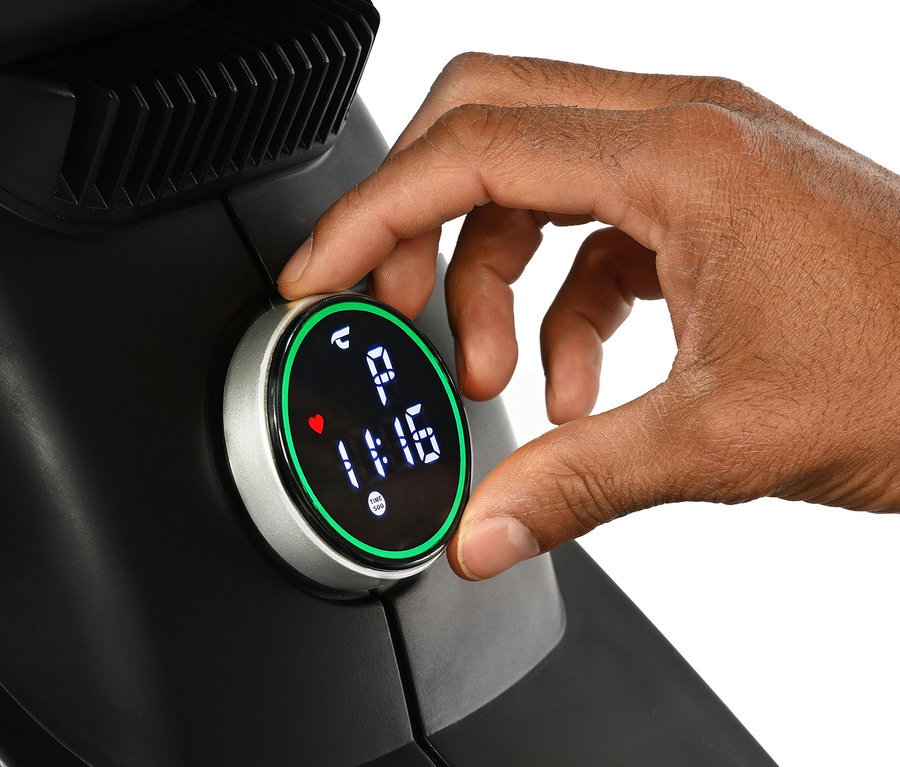 Eine Hand stellt den Timer auf einem schwarzen Rudergerät »Ergometer Vico« ein.