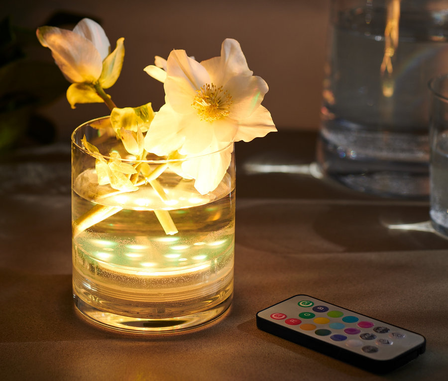 Blumen in Vase mit LED-Unterwasserlicht mit Farbwechsel und Fernbedienung.