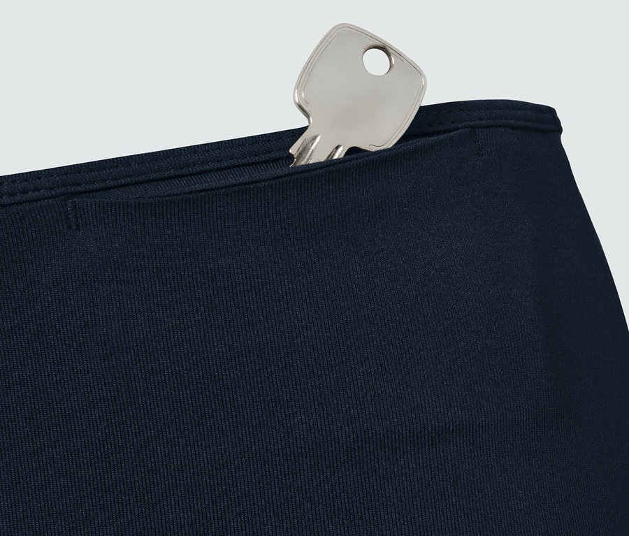 Schlüssel in der Tasche einer navy Sporttight.