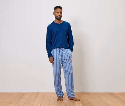 Mann trägt blauen Langarmpyjama und gestreifte Hose.