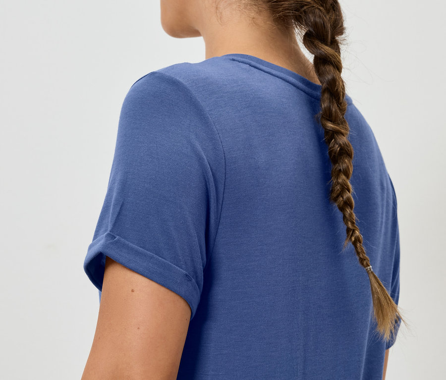 Frau mit Zopf trägt blaues T-Shirt.