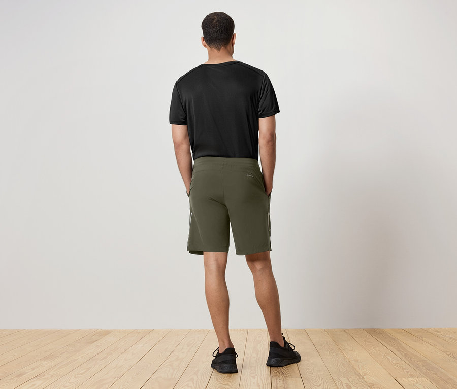 Mann von hinten trägt ein schwarzes T-Shirt und grüne Shorts.