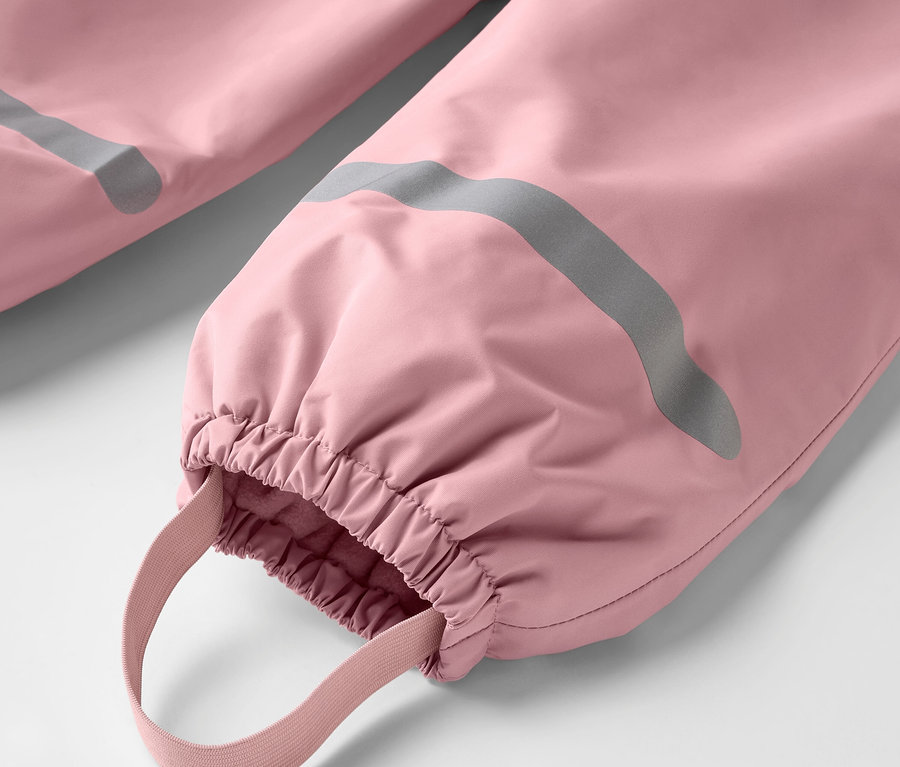 Detail einer Kinder-Thermo-Regenhose, rosa, mit silbernem Reflexstreifen und elastischem Beinabschluss.