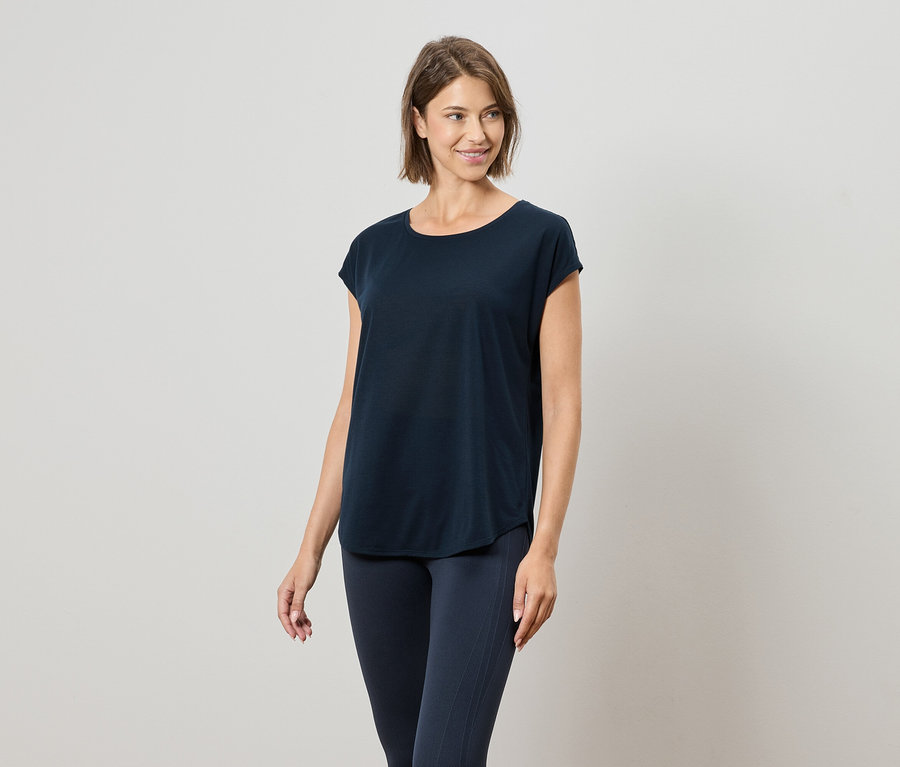 Frau trägt ein marineblaues T-Shirt und marineblaue Leggings.