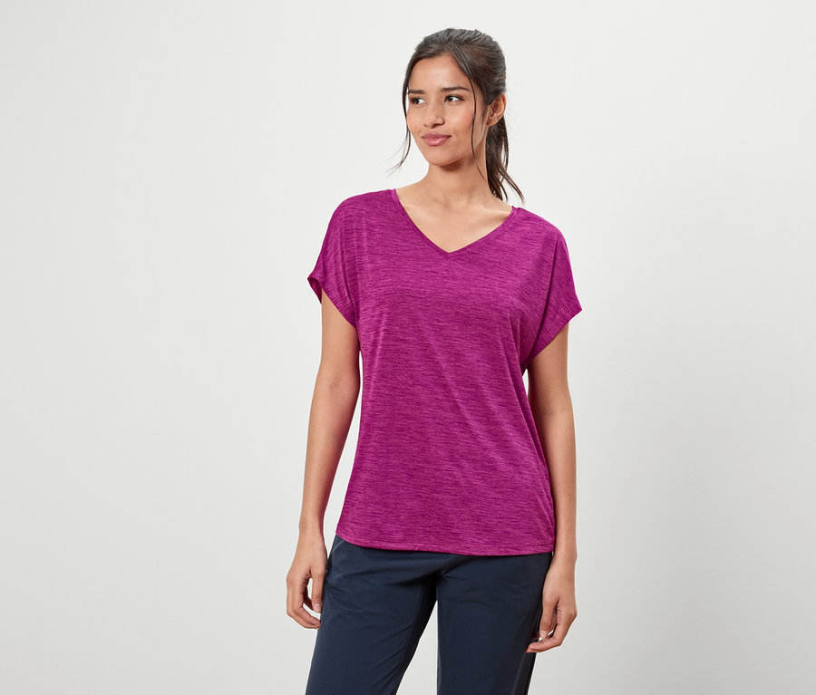 Frau trägt ein violettes T-Shirt und blaue Hosen.