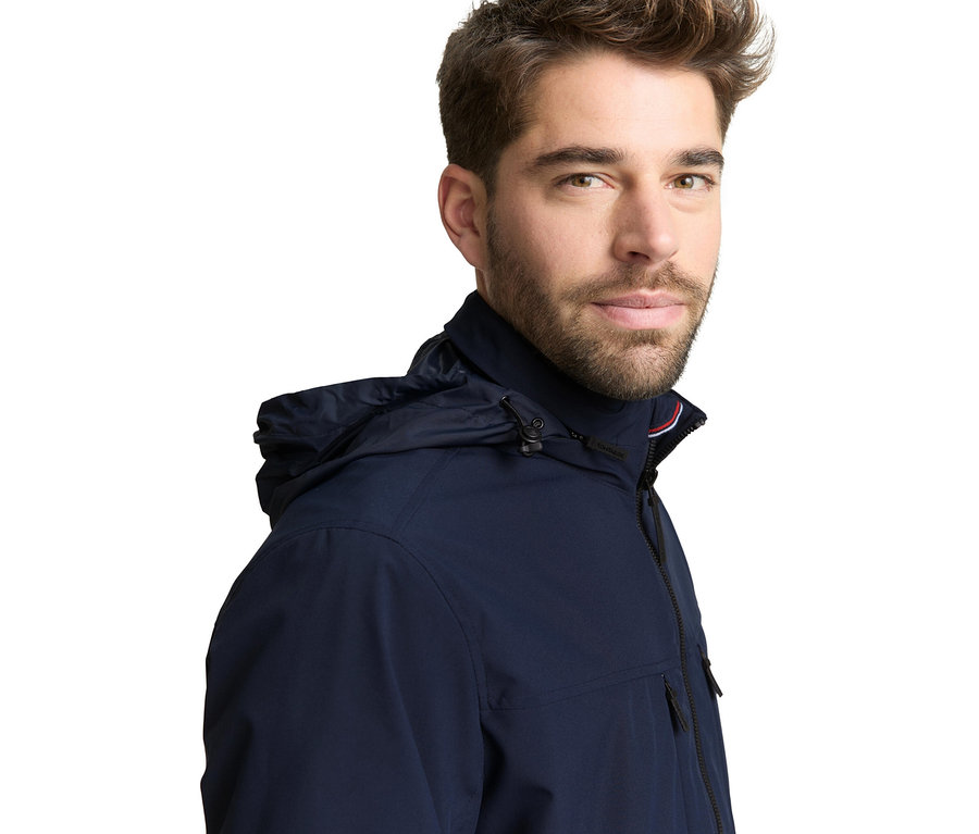 Mann trägt eine Tom Tailor Blouson-Jacke in Sky Captain Blue mit Kapuze.